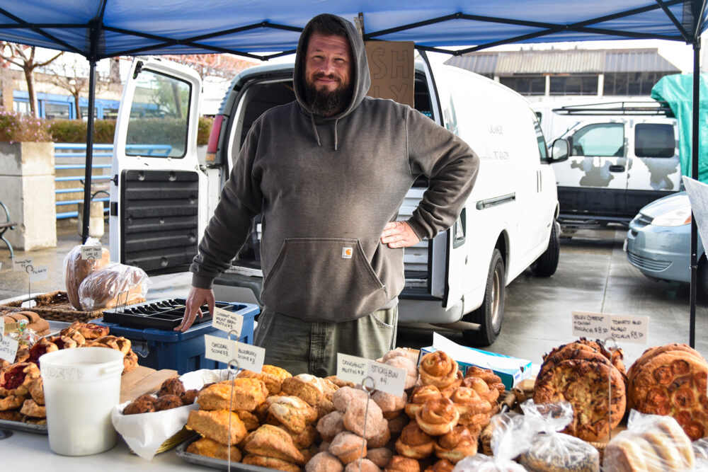 Ross poses at Downtown Bakery's stand at the Ferry Plaza Farmers Market in San Francisco.