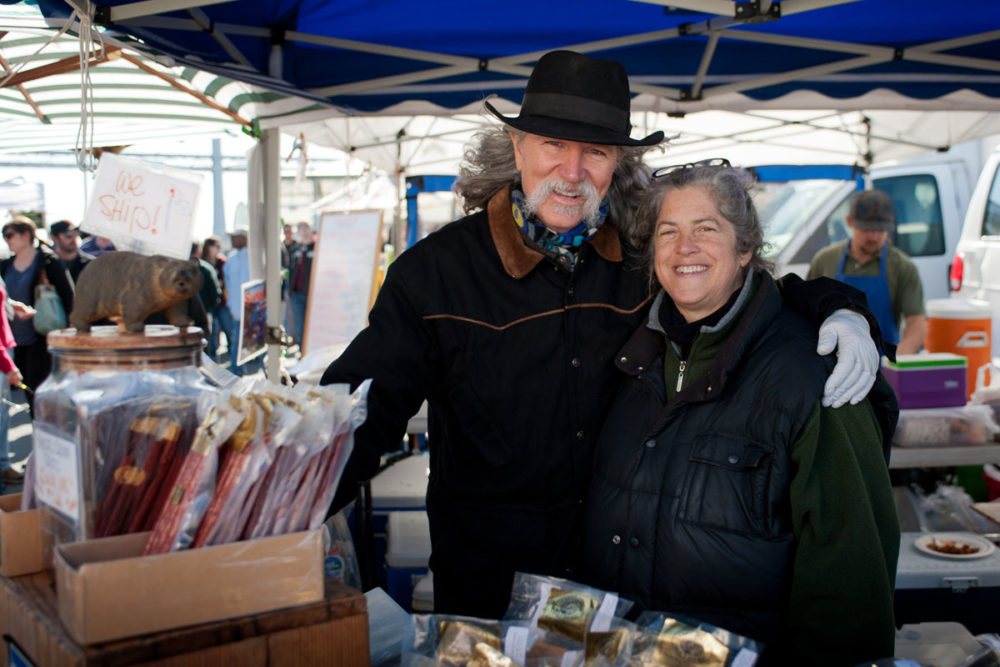 Mike and Sally pose at Cap'n Mike's Holy Smoke's stand at the Ferry Plaza Farmers Market in San Francisco.