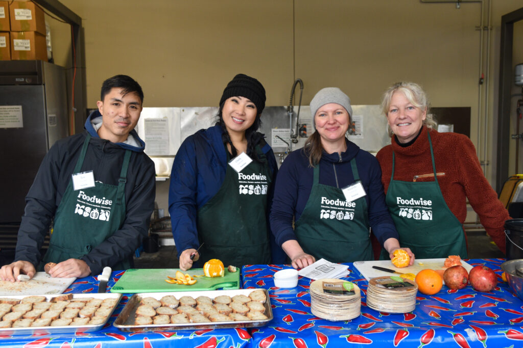 Photo of Foodwise volunteers and farmers market seller Audrey Hitchcock preparing food samples.